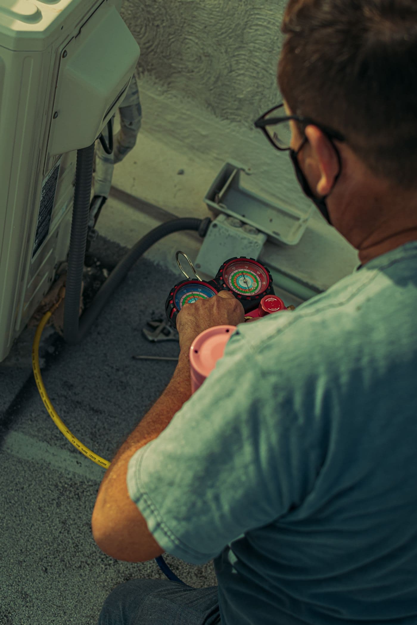 Technician focused on servicing an outdoor air conditioning unit
